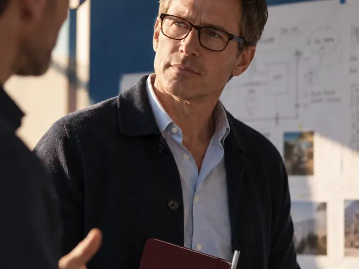 An architect talking through drawings in a studio.