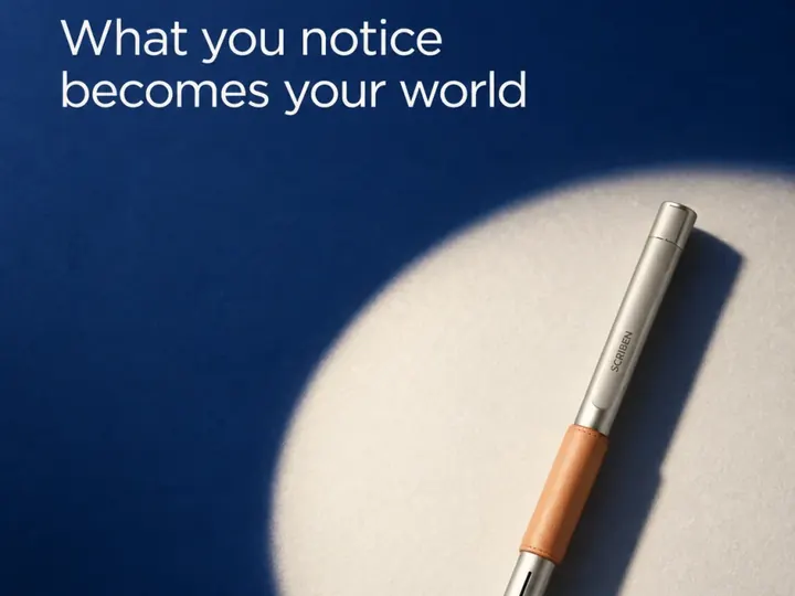 What you notice becomes your world. A pen lit on deep blue.